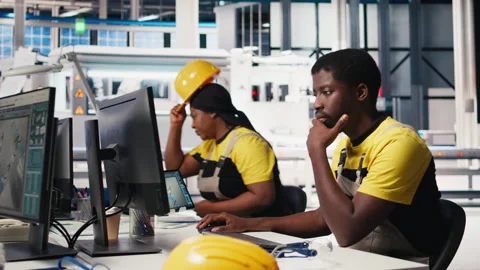 Black engineer works on solar software settings in automated factory Stock Footage 309073846