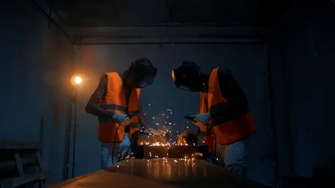 Black engineers workers work on welding metal in a dark atmosphere. Stock Footage 128748211