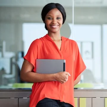 Black entrepreneur smiling at camera while standing in business lounge Stock Photos