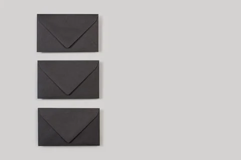 Black envelopes on a gray background in a top view Stock Photos