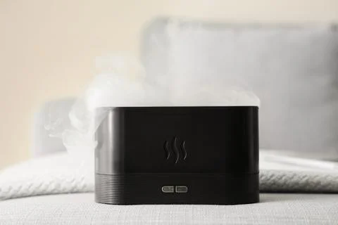 Black essential oil diffuser emitting steam for aromatherapy and relaxation i Stock Photos
