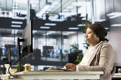 Black executive analyst finalizes a financial report and reviews data insights Stock Photos