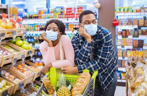 Black family in face masks buying food, tired of shopping for groceries at Stock Photos