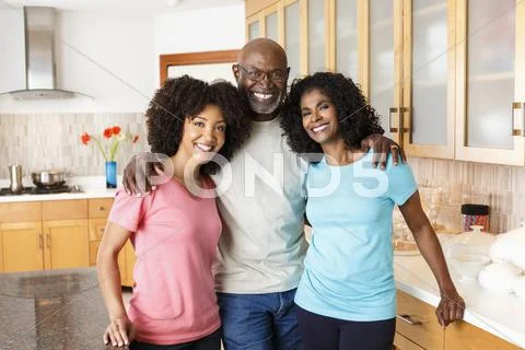 Black Family Hugging In Kitchen