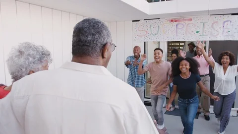 Black family running to welcome grandparents outside their home for a surprise Stock Footage