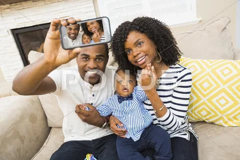 Black Family Taking Selfie On Sofa In Living Room