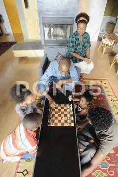 Black Family Watching Chess Game