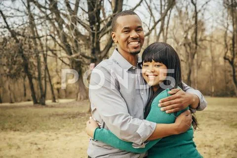 Black Father And Daughter Hugging Outdoors