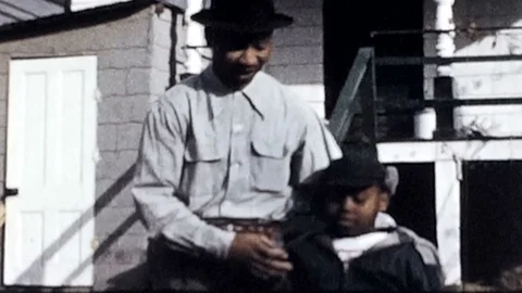 Black father and son play around in frontyard 1950s vintage film home movie 4716 Stock Footage 86832384