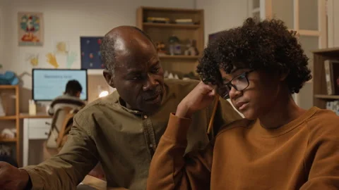 Black Father Explaining Son Grammar Rules for Writing Test at Home Stock Footage 334967717