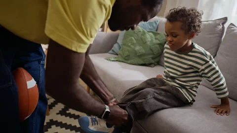 Black Father Helping Son Getting Ready to Play at Home Vídeos de archivo 345497561