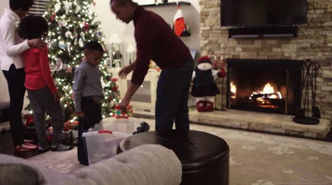 Black father lifting son to put star on top of Christmas tree 스톡 동영상 67007284