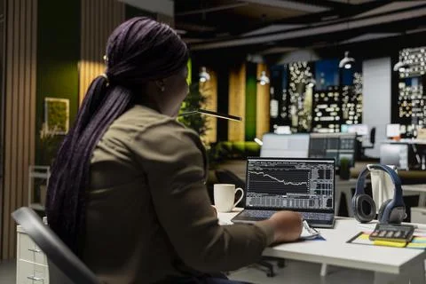Black female administrator analyzes data on stock and forex trading Stock Photos