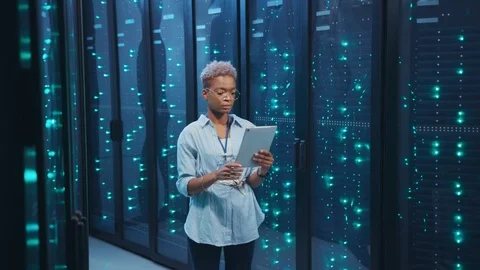 Black female administrator with tablet activating network servers in database Stock Footage 119842401