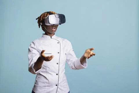 Black female chef using VR headset in virtual cooking simulation Stock Photos
