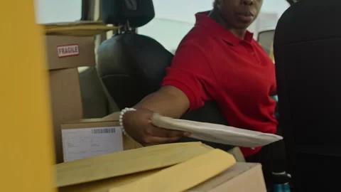 Black Female Courier Taking Parcel from Back Seat of Car Stock Footage 280375166