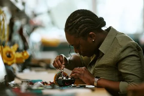 Black Female Engineer Soldering Microchip in Tech Laboratory Stock Photos