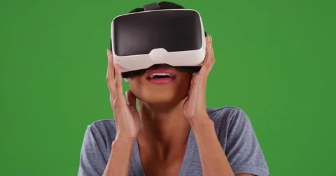 Black female in her 20s using smartphone vr headset on green screen Video stock 79405560