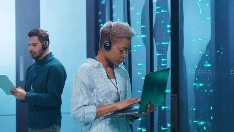 Black female IT engineer examining rack server cabinet in high tech room Video stock 119842320