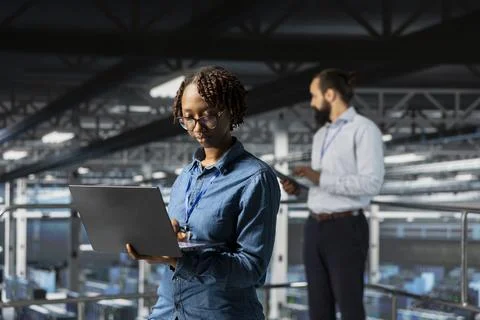 Black female programmer working on laptop in data center Foto stock
