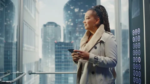 Black Female Riding Elevator to Office Using Smartphone Stock Footage 167827341