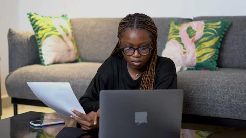 A black female student comparing notes on a laptop while studying Stock Footage 265238647