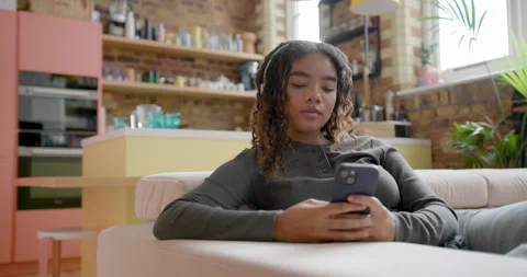 Black Female Student on Sofa using Phone Relaxing at Home Stock Footage 297264328