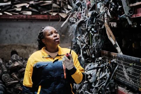 Black female supervisor checks auto spare parts stock at stack warehouse. Foto stock