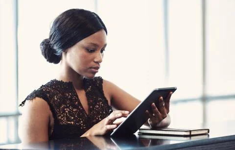 Black female using a digital tablet with serious facial expression Stock Photos