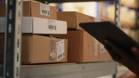 Black female worker using scanner checking airway bill numbers in inventory Foto stock