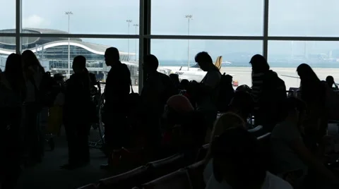 Black figures passengers queue departure gate against terminal window Stock Footage 56150824