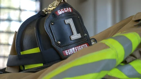 Black firefighter helmet on top of a protective fire coat inside a fire Stock Footage 110852999