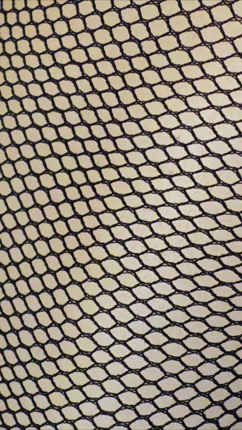 Black fishnet nylon elasticated mesh fabric texture background. Stock Footage 297867186
