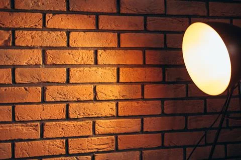 Black fixture of lamp hanging on the brown bricks wall. Stock Photos