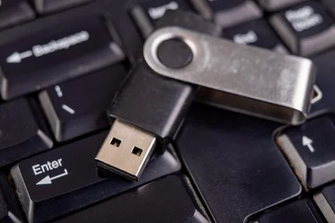 Black flash drive on a PC keyboard. Cache used to store temporary data. Stock Photos