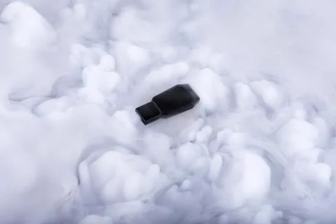 Black flash memory stick in the Information clouds Stock Photos