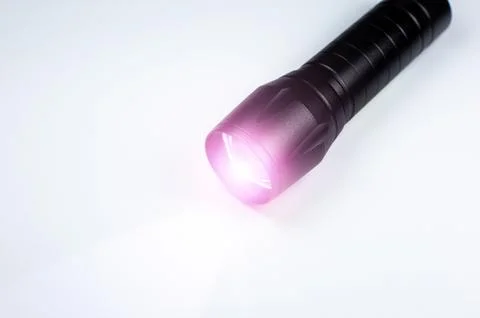 Black Flashlight and a ray of light on the white background. Close up photo. 스톡 사진