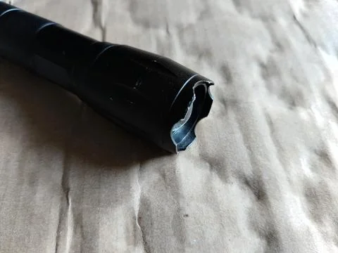 Black flashlight on cardboard background. Фото