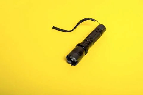 Black flashlight shocker on a yellow background Foto stock