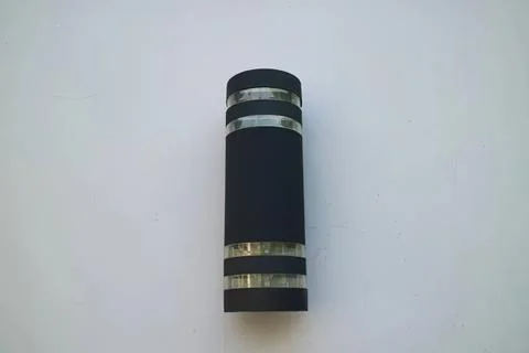 Black flashlight with silver rings on a white background Stock Photos