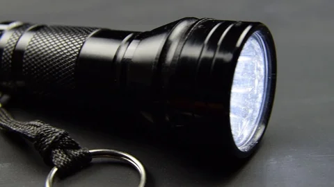 Black flashlight torch lying on a black table surface Stock Footage 121144924