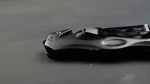 Black folding knife on a black surface table Sharp edge blade 02 Stock Footage 121144973