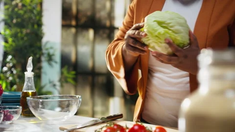 Black food content creator preparing iceberg salad leaves on cooking video Stock Footage 333610792