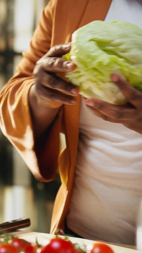 Black food content creator preparing iceberg salad leaves on cooking video Stock Footage 333616875
