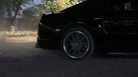 Black Ford Mustang model drifting and burning tires on a dusty road. Stock Footage 157264803