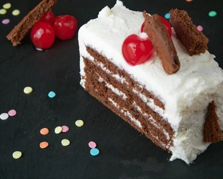 Black forest slice decorated with cherries, small pieces of cake and decorati Stock Photos