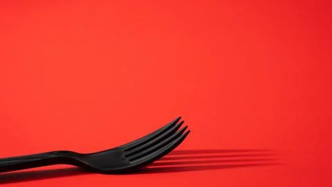 Black fork on a red background Stock Photos
