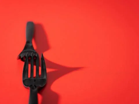 Black fork on a red background Stock Photos