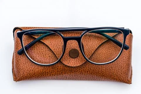 Black frame spectacles resting on a brown leather case Stock Illustration