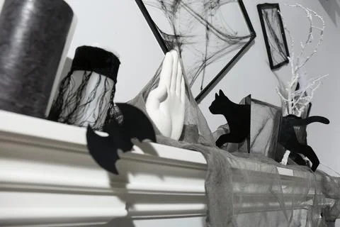 Black frames with cobweb on white wall and different Halloween decor on firep 스톡 사진